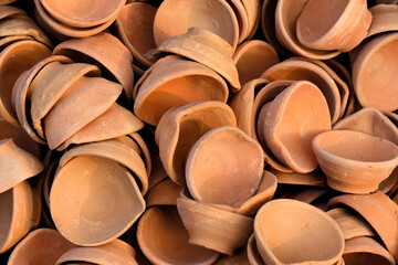 03 November 2023, Pune, India, An Potter applies colour to earthenware oil pots or diyas at a...