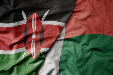 big waving national colorful flag of kenya and national flag of madagascar .
