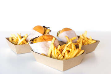 Burgers with fries lie on the table in delivery boxes