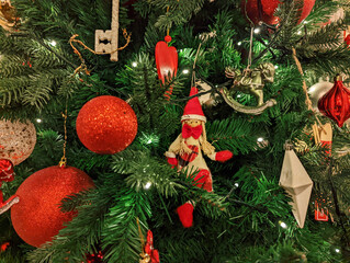 Red toy balloons are hanging on the Christmas tree. close-up