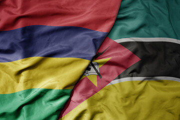 Obraz premium big waving national colorful flag of mauritius and national flag of mozambique .