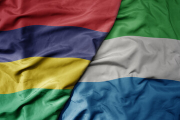 big waving national colorful flag of mauritius and national flag of sierra leone .
