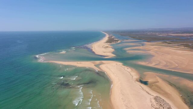 Aerial video filming by drone of the marine reserve Ria Formosa Faro Portugal Algarve. Praia de Barrinha. Flight over the coastal spit between the park and the ocean with a view of the canal.