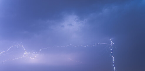 Lightning from the black and blue sky. Storm clouds.