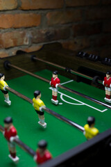 Table football vertical photo. Wooden board game with crossbars with plastic people attached