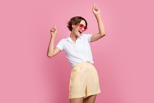 Photo of funky positive nice girl with bob hairdo dressed white shirt dancing in heart shape glasses isolated on pink color background