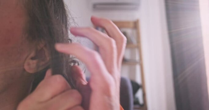 Man nervously brushes the unruly hair on his head with fingers. Side view, close-up. Concept of nerves, itching, bad hair, unwashed head.
