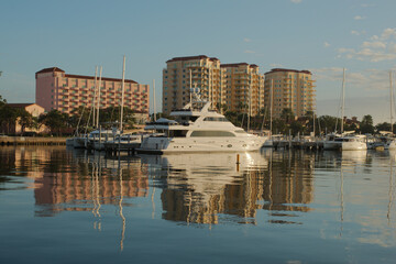 Cityscape of water with tall buildings with reflections on a sunny day with boats in the foreground. With a blue sky on a sunny day at the Vinoy Basin waterfront in St. Petersburg, Florida.