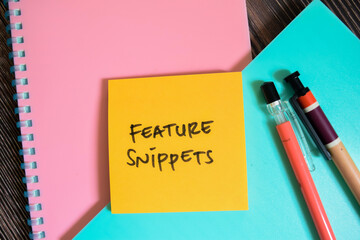 Concept of Feature Snippets write on sticky notes isolated on Wooden Table.