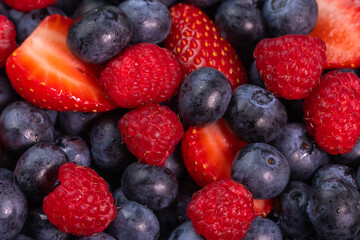 Bright background berry mix of blueberries, raspberries, strawberries, macro photography. Salad of their fresh berries, summer time.