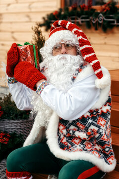 Saint Nicholas in festive decoration against the background of a wooden house