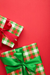 A green gift with ribbon on red background. Christmas concept