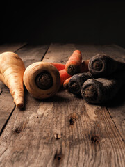 Three different root vegetables on a rustic wooden table