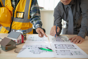 Construction engineers discuss and exchange ideas with architects to improve house plans to meet customer needs. A concept for exchange of design ideas between construction engineers and architects. - obrazy, fototapety, plakaty