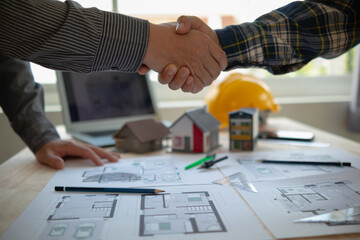 construction engineer joins hands with architect to congratulate housing project that architect team has designed and has been accepted by engineering team. concept of handshake for congratulations - obrazy, fototapety, plakaty