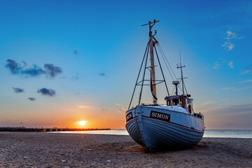 Fishing boats on the beach at sunset in Vorupor, Denmark. - obrazy, fototapety, plakaty