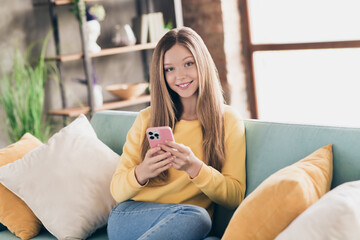 Portrait of positive cute girlish schoolgirl with long hairstyle wear stylish sweatshirt hold...