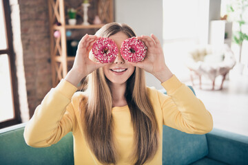 Closeup photo of funny playful teenage girl hold hands fresh glazed sweet doughnuts like binoculars...