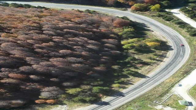 Curvy mountain roads in autumn. Vehicles in motion on winding mountain roads. 