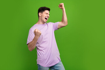Fototapeta premium Portrait of overjoyed crazy person with stylish haircut wear violet t-shirt win lottery loud shouting isolated on green color background