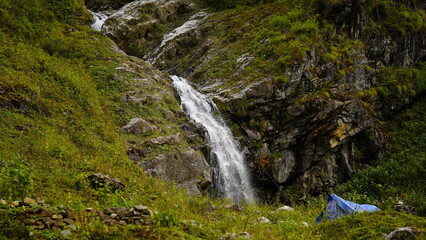 a beautiful waterfall falling down between the hills