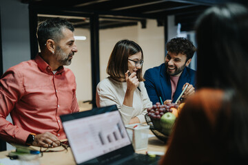 Business team analyzing data, discussing strategies for growth, and collaborating in a creative office to meet project deadline. Late night dedication for profitability and achievements.