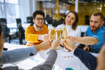 Colleagues in the office celebrate the concluded deal with champagne and sparkling wine. A group of...