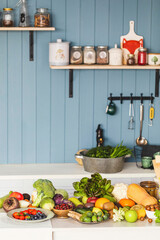 Fresh raw healthy food on a white table in the kitchen at a country cottage, indoor, copy space, vertical photo, selective focus.