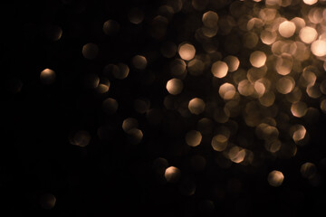 Golden large abstract bokeh on a black background. Holiday concept, blurred bokeh, overlay for your...
