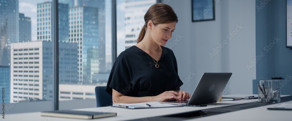 Poster caucasian businesswoman standing in her corner office next to big window with city view and using la