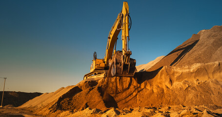 Construction Site On A Hot Sunny Day: Industrial Excavator Digging Sand To Lay Foundation for...