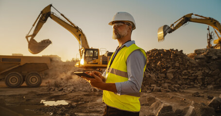 Caucasian Male Civil Engineer Wearing Protective Goggles And Using Tablet On Construction Site On...