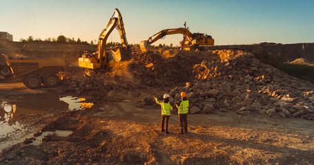 Aerial Drone Shot Of Construction Site On Sunny Evening: Industrial Excavators Digging Rocks And...