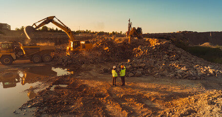 Aerial Drone Shot Of Construction Site On Sunny Day: Industrial Excavators Digging Rocks And...