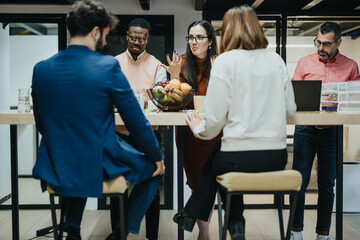 A creative team of businesspeople collaborating in a late-night workshop, discussing strategies and analyzing data for project development and business growth.