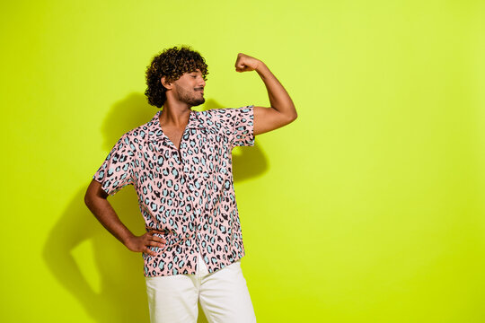 Photo portrait of attractive young man flexing muscles dressed stylish pink leopard print clothes isolated on yellow color background
