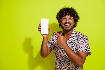 Photo portrait of attractive young man device point screen dressed stylish pink leopard print clothes isolated on yellow color background