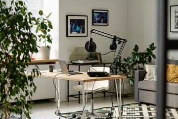 Workplace of modern host, blogger or deejay with podcasting equipment such as laptop, microphone, headphones and soundboard