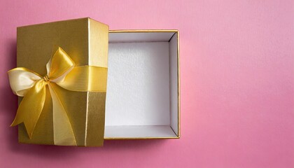 open gift box and gold bow on pink background with copy space for your message,