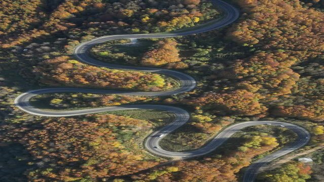Curvy mountain roads in autumn. Vehicles in motion on winding mountain roads. 