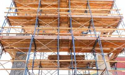 Construction site with workers, tools, and safety gear amidst yellow caution signs, showcasing industrial activity and safety protocols