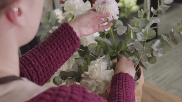 Young Woman Creating a Beautiful Floral Arrangement in a Cozy Flower Shop