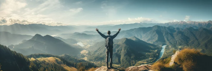 Foto op Plexiglas Traveler standing on top of a mountain with hands raised up , mission success and goal achieved, active tourism and mountain travel © pundapanda