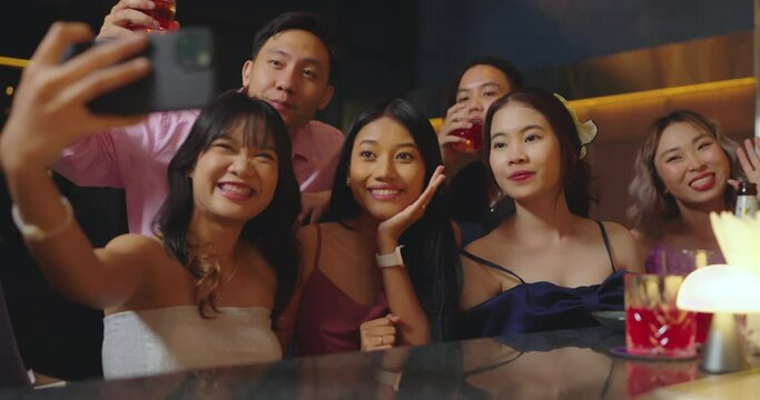 Beautiful young asian woman using phone and taking selfie with friend in bar. They Enjoying with Night Party Together. Party, Lifestyle, Happiness, Cheerful and Celebration Concept.