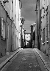 Ruelle typique d'une petite ville du sud de la France dans un quartier populaire, en noir et blanc.