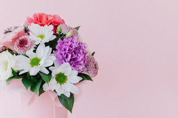 Beautiful bouquet of pink. violet and white flowers on a pink pastel background.