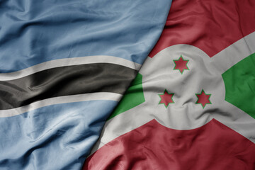 big waving national colorful flag of botswana and national flag of burundi .
