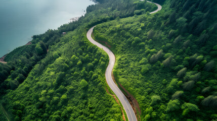 Top view of countryside road passing through the green forrest and mountain