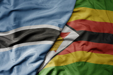 big waving national colorful flag of botswana and national flag of zimbabwe .