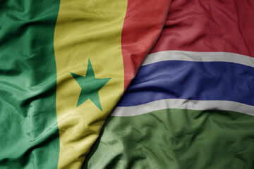 big waving national colorful flag of senegal and national flag of gambia .